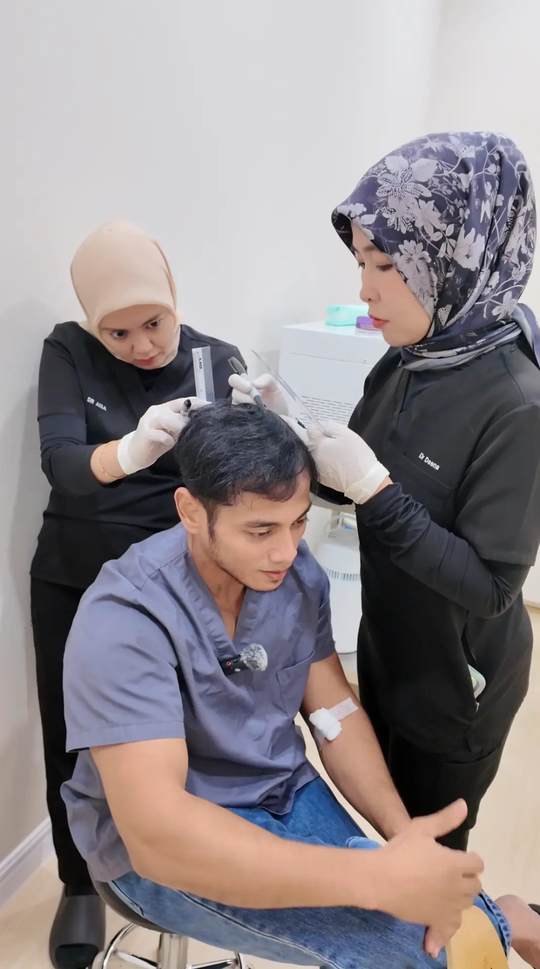 Dr Deena and Dr Aisa of Thrive Hair Clinic marking a patient's hairline together