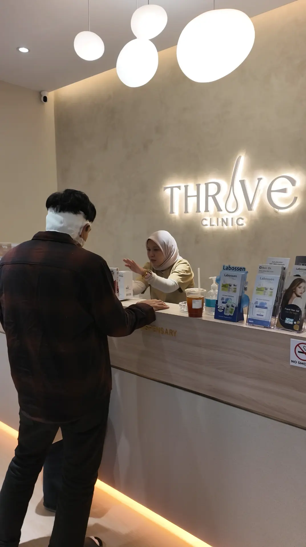 A post-transplant patient at the Thrive Hair Clinic reception during a follow-up visit